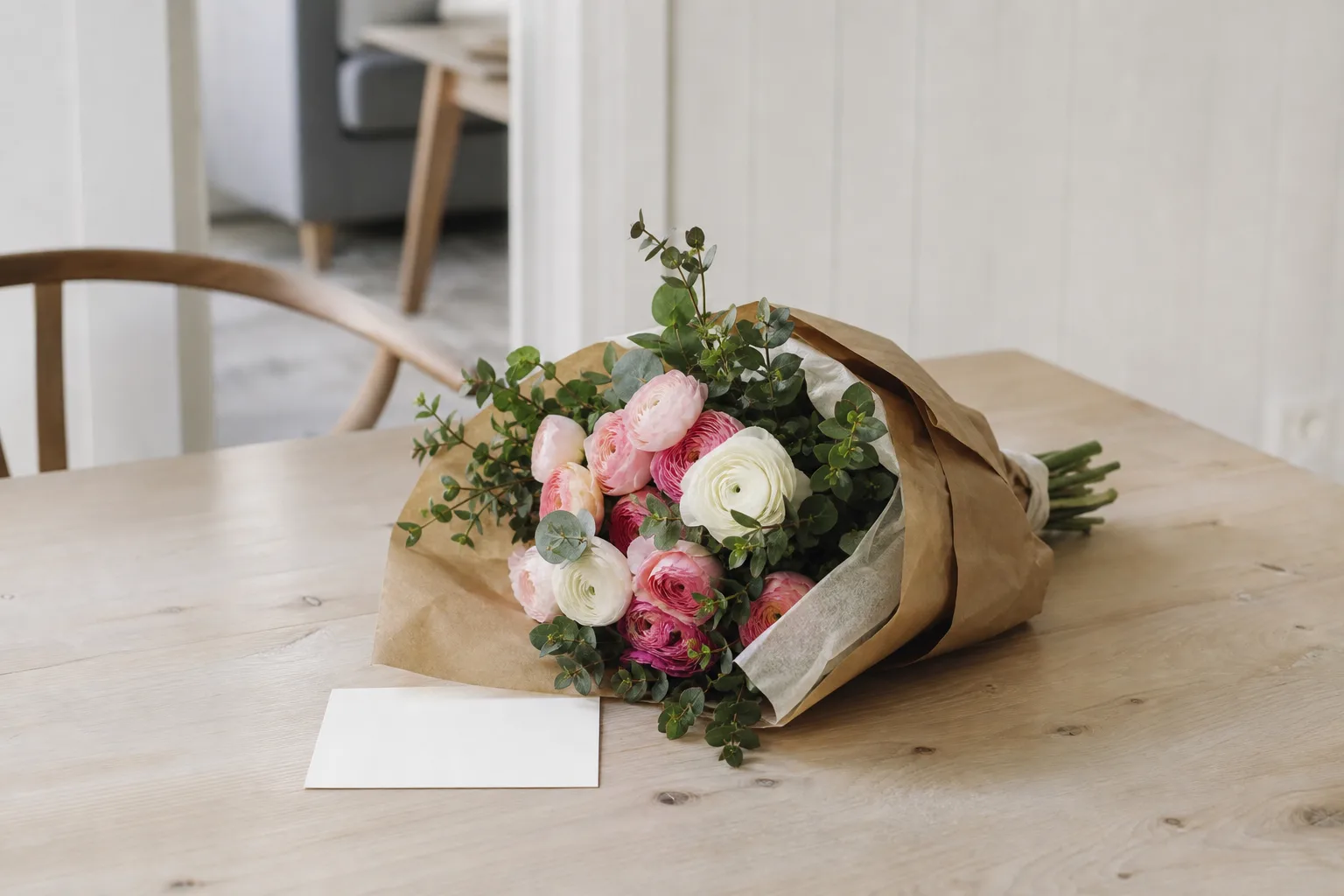 Bukett med säsongens snittblommor inslagen i kraftpapper.