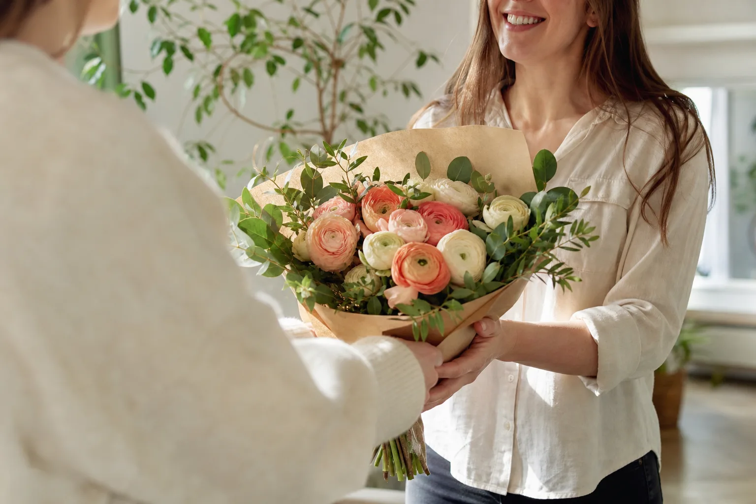 Bukett med enkla säsongsblommor uppställd på ett träbord.