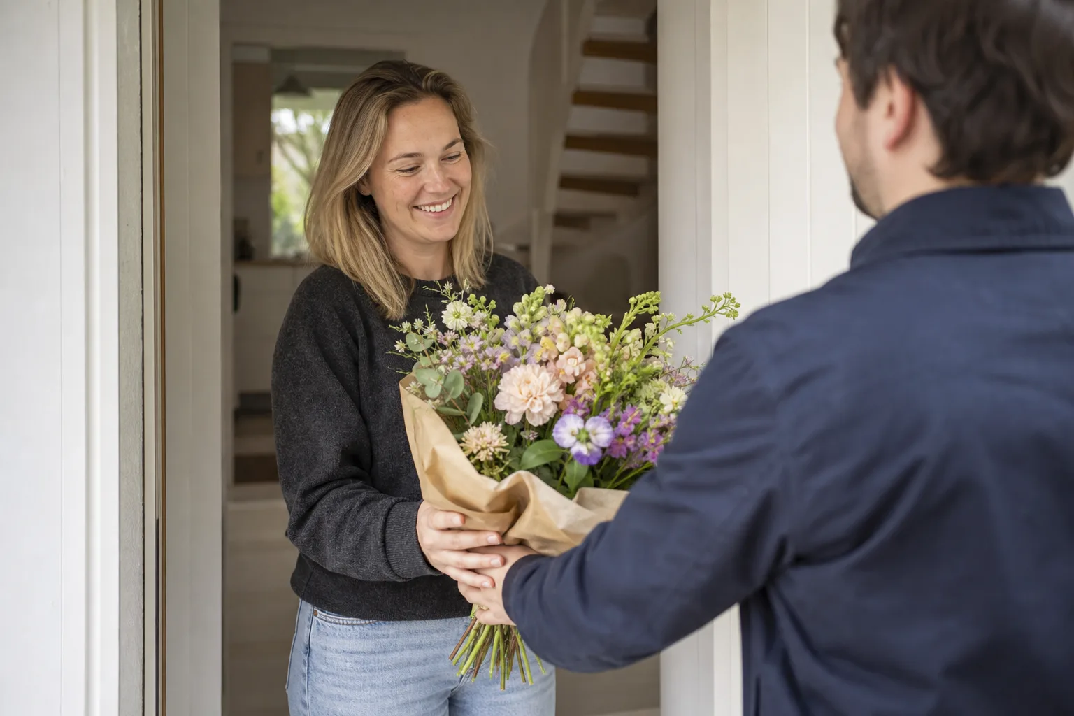 Färgstark bukett med säsongsblommor uppställd på ett bord, klar att packas för bud.