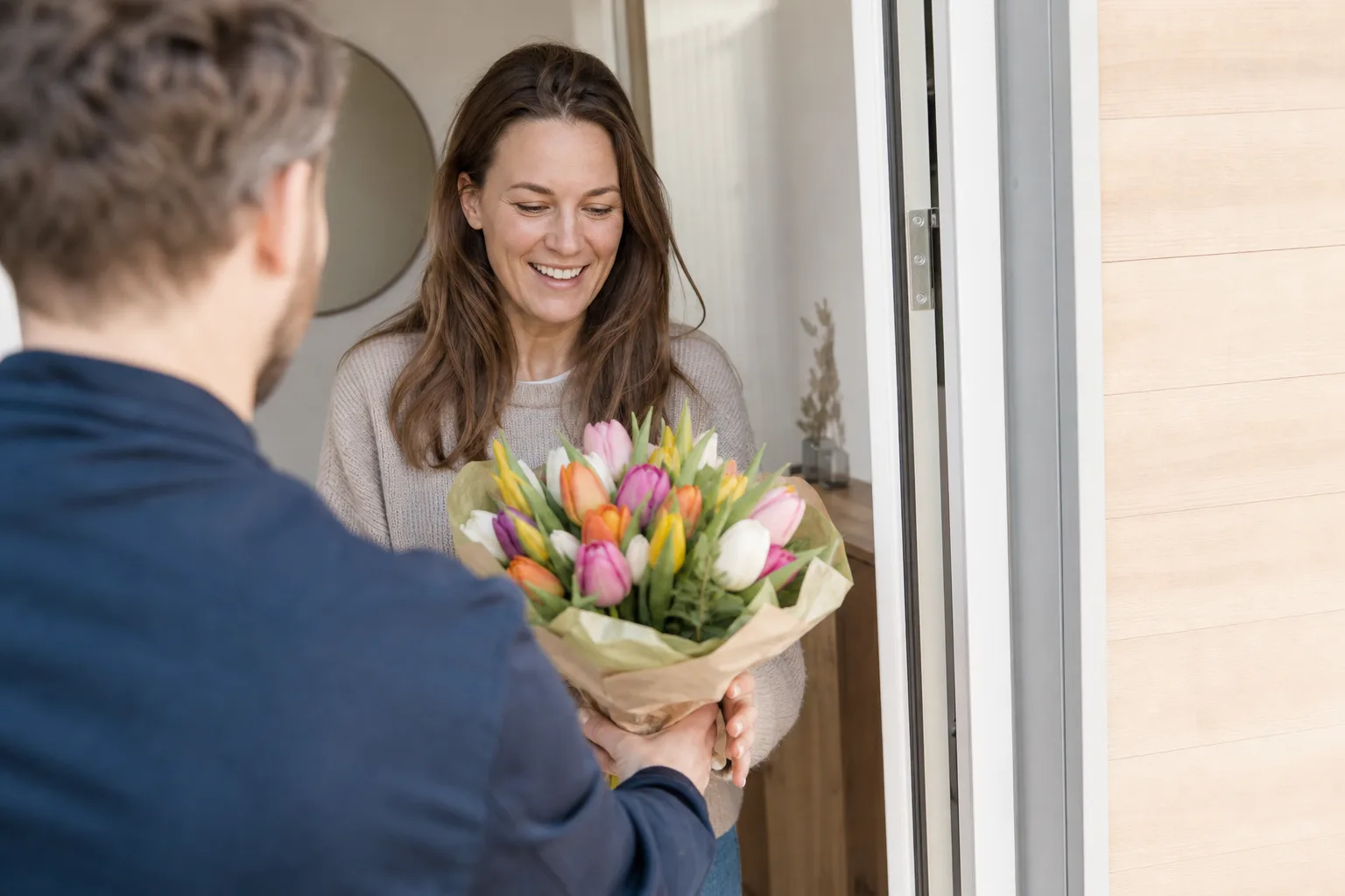 Bukett med säsongsblommor i papper, redo att lämnas över vid leverans
