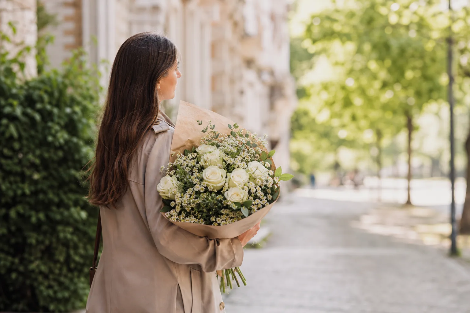 Bukett med säsongsblommor i varma höstfärger, uppställd på ett bord