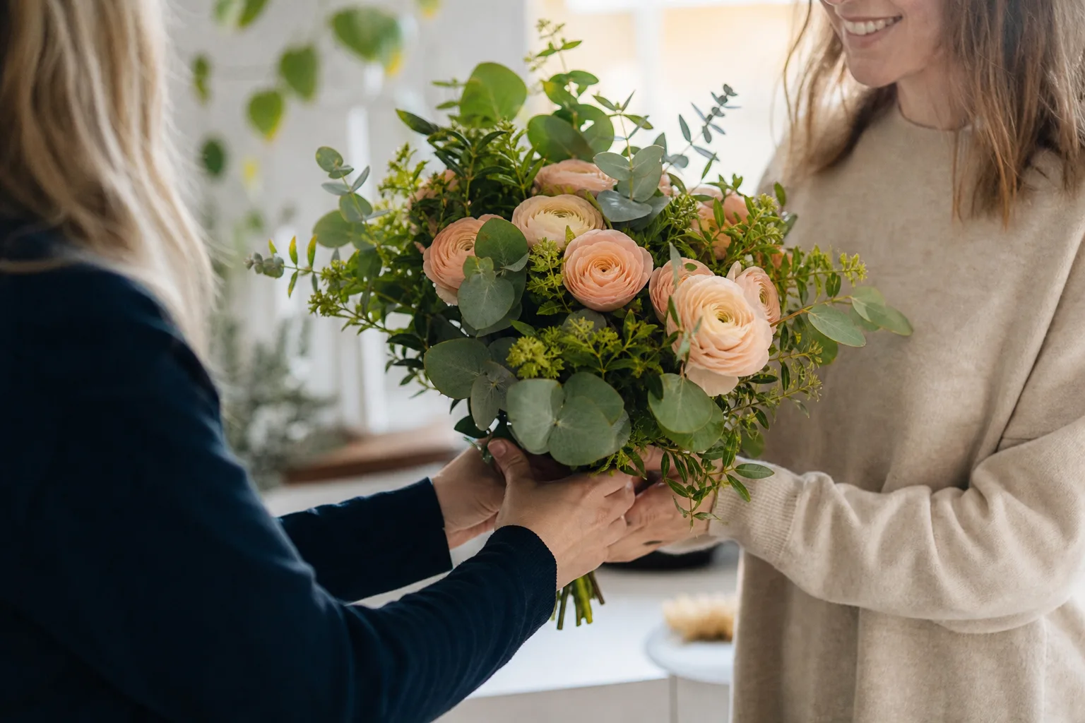Närbild på en bunden bukett med gröna blad och färgstarka blommor.